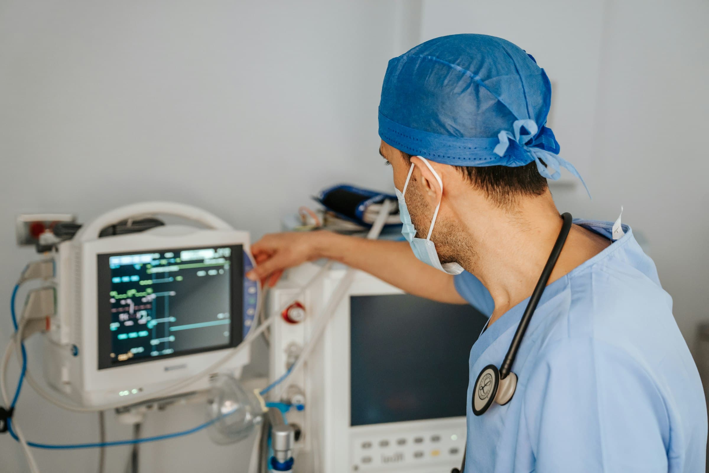 A clinician adjusting a patient monitor.